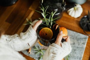 a person holding a cup with a lemon and rosemary