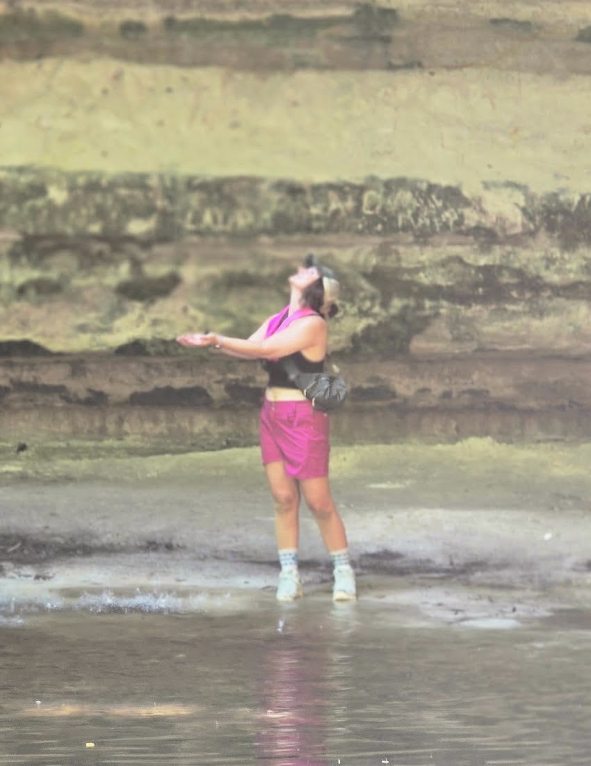 woman standing under water fall
