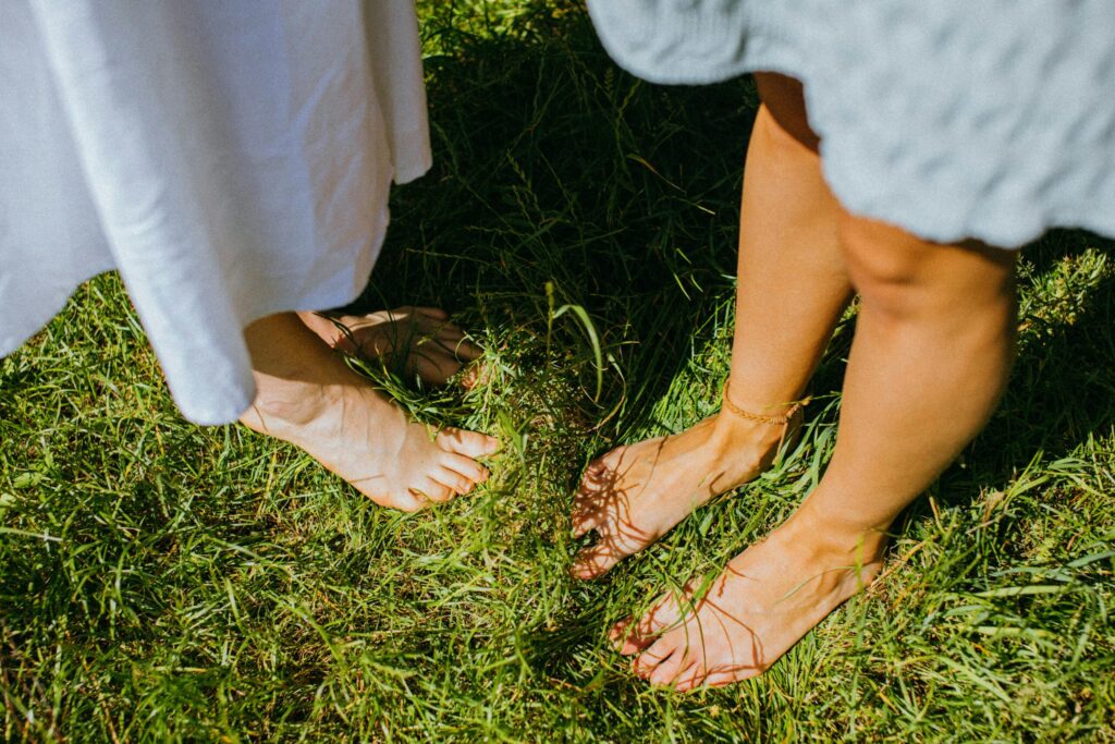 Two women standing quietly with feet on the ground, grounding practice for nervous system support