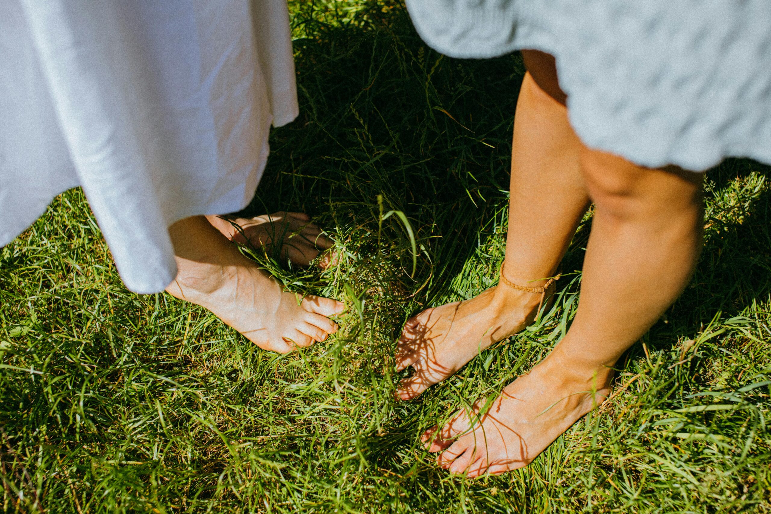 Two women standing quietly with feet on the ground, grounding practice for nervous system support
