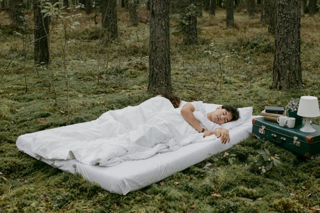 Tired of being tired? Let's get back to the basics with restorative sleep 3 couple sleeping on a bed in the forest